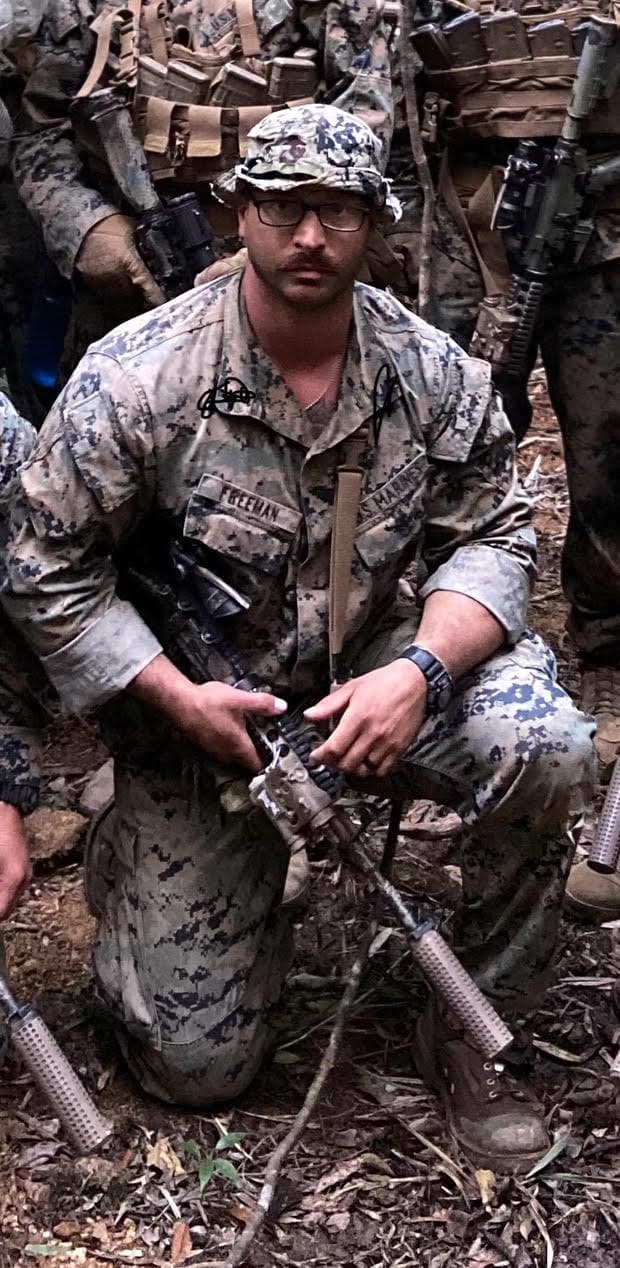 Brian in Marine Corps camouflage, kneeling in the field